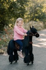 Small horse on wheels Ponnie Ebony S with a pink saddle